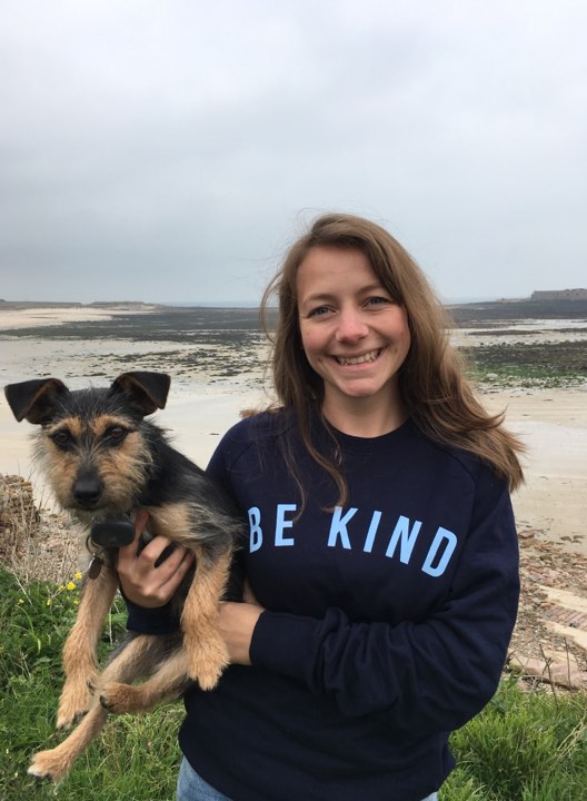 Vet Joanna Woodnutt holding dog with beach in background