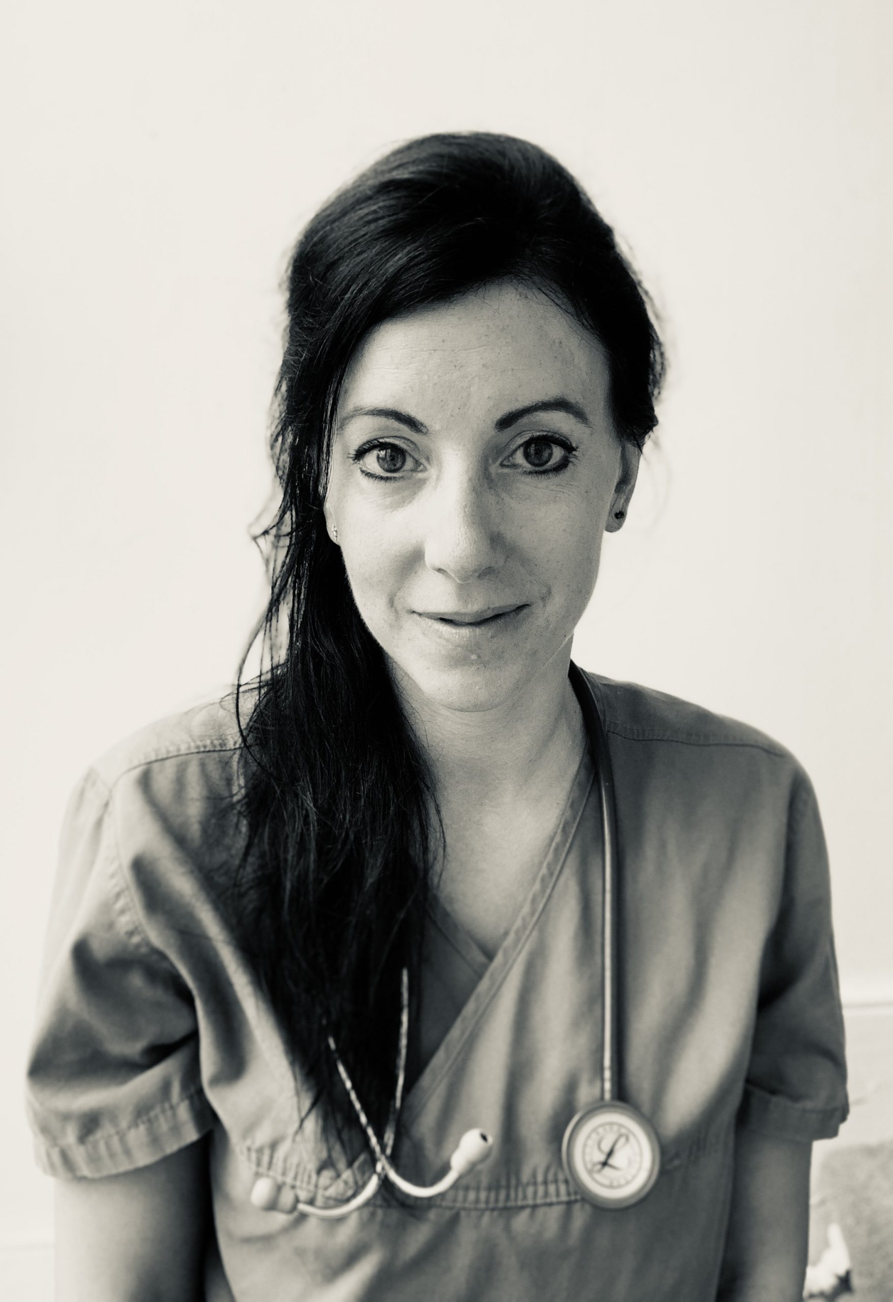 Rosalind Wright, vet writer. (A white woman with black hair is looking at the camera. She is wearing scrubs and has a stethoscope around her neck)