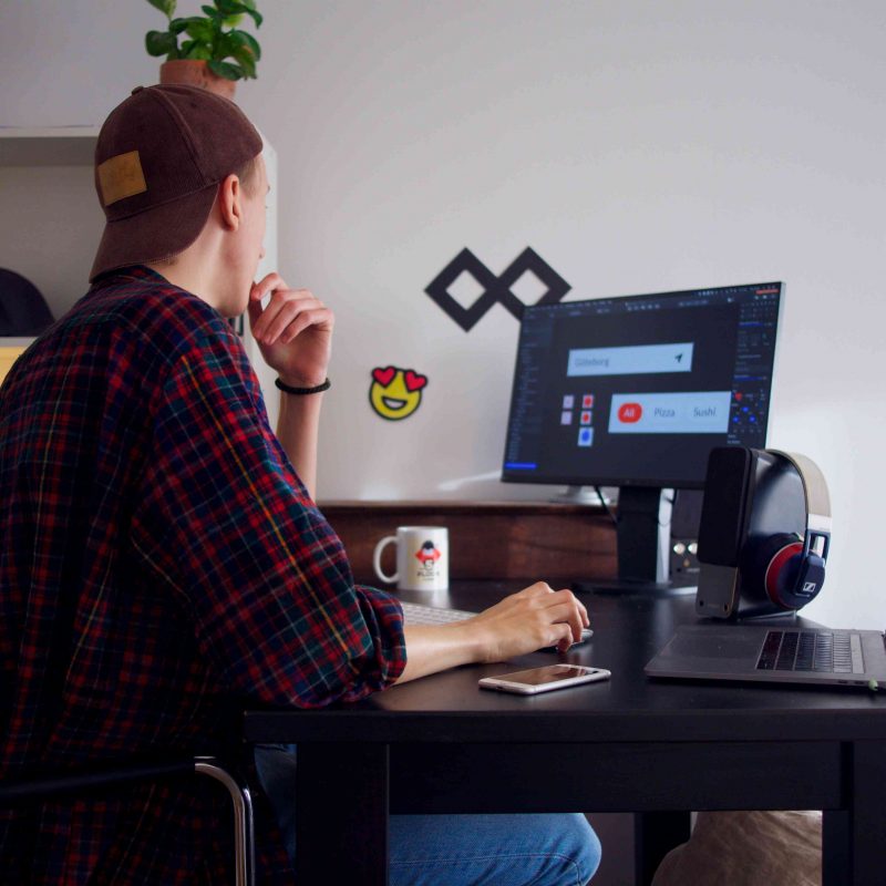A freelance pet writer wearing a checked shirt sits at their computer