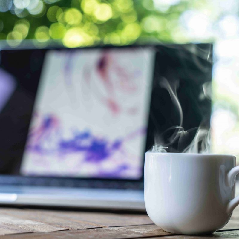 A hot drink sits beside a laptop. This is a day in the life of a veterinary content writer