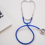 Stethoscope next to a laptop - how to hire a veterinarian for content marketing