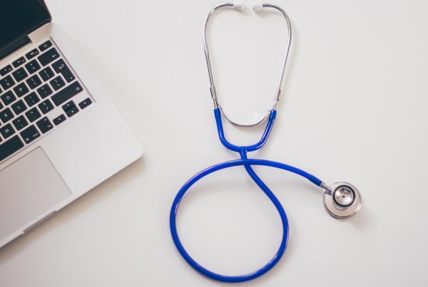Stethoscope next to a laptop - how to hire a veterinarian for content marketing